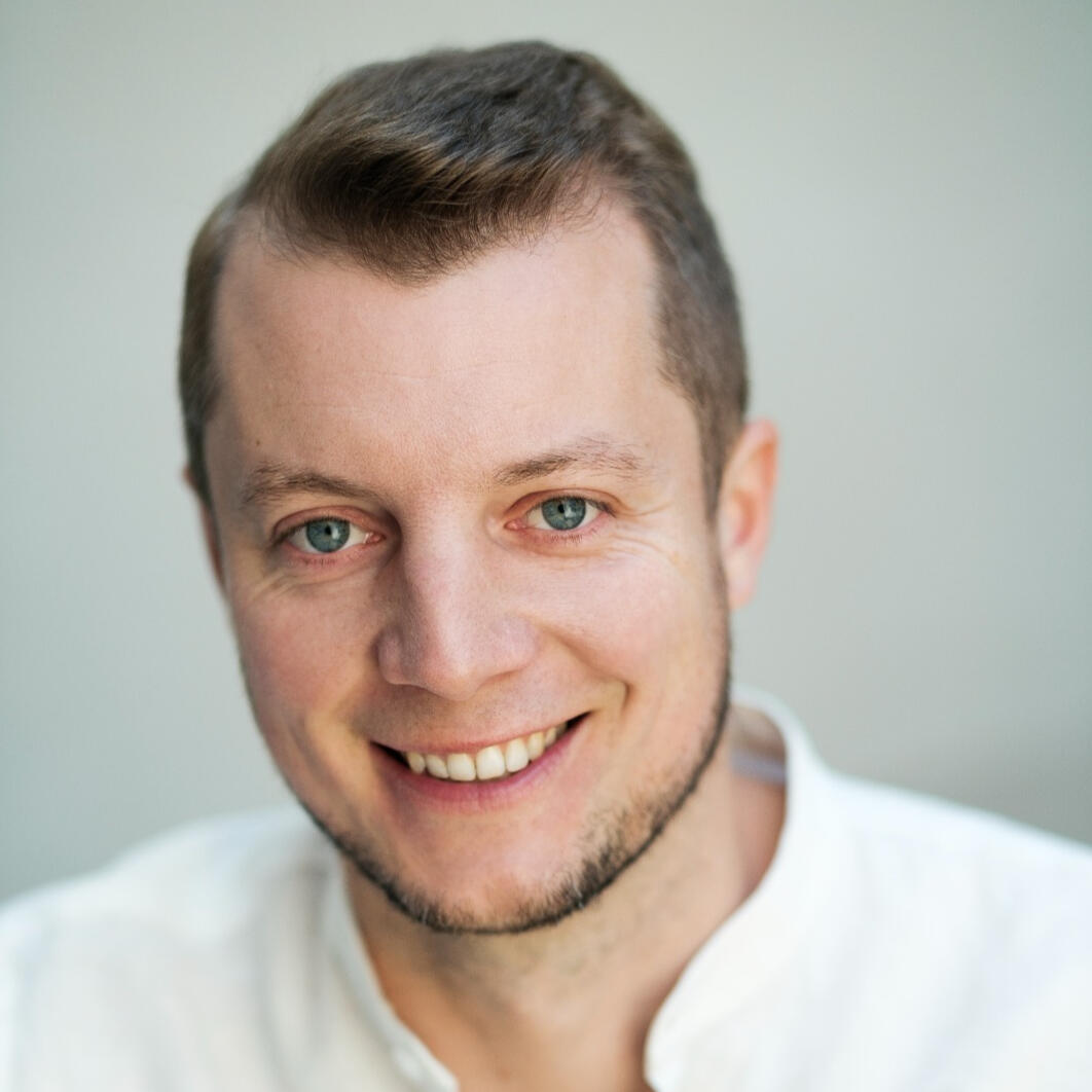 Mistrz kondycji i zabawy. Michał Pietrzak – prowadzący zajęcia „Akademia Sprawności”, portret uśmiechniętego mężczyzny.